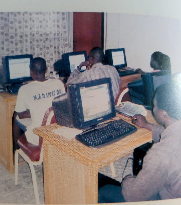 Students at computers in the Ajasin Foundation's ICT centre; the student in the foreground wears a white t-shirt reading 'M.K.O. Lives On', referencing M.K.O. Abiola, whose 1993 SDP victory Pa Ajasin championed.